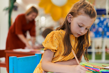 Image showing Creative kids sitting in a preschool institution, draw and have fun while they get an education