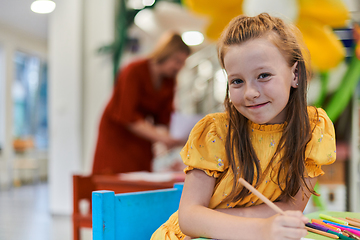 Image showing Creative kids sitting in a preschool institution, draw and have fun while they get an education