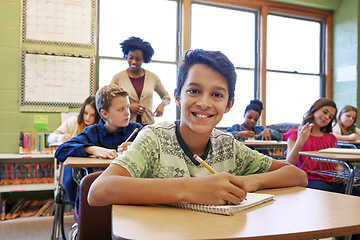 Image showing Happy, education portrait or kid in classroom writing in notebook for learning, research or study for exam with teacher. Scholarship, thinking or student in school for test, academy or assessment