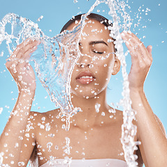 Image showing Woman, hands or washing face in water splash on blue background studio for dermatology healthcare, hygiene wellness or self care grooming. Beauty model, facial cleaning or wet water drops in bathroom