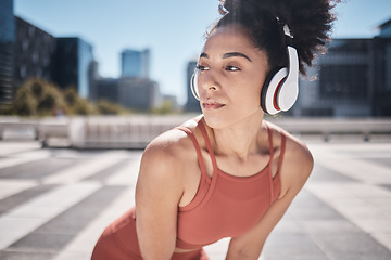 Image showing Fitness, headphones and rest, woman runner stop to relax or breathe on city run or workout. Health, urban training and wellness, a tired black on break from running exercise while streaming music app