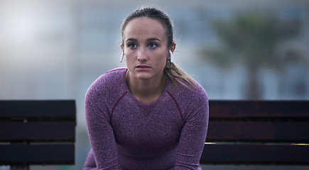 Image showing Focus, thinking and fitness woman outdoor for city workout and wellness exercise in marathon running. Runner, break and mindset for sports training with music earphones, motivation or vision of goals