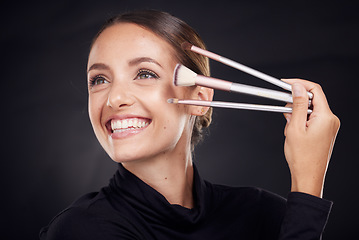 Image showing Makeup, brush or model with beauty luxury products or cosmetics for self care in studio on black background. Skincare, relax or young woman brushes foundation powder or eyeliner in facial treatment