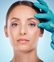 Image showing Plastic surgery, skincare and woman with injection, healthcare and on blue studio background. Female, girl and botox with cosmetics, wellness and face care for health, soft and smooth skin for beauty