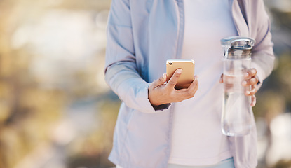 Image showing Running, water and phone with hands of woman in mountain for jogging, workout or cardio training. Social media, progress tracker or fitness app with runner on path checking mobile for endurance goals