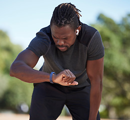 Image showing Fitness, black man and smart watch time for running exercise, workout challenge or healthy marathon training. Stopwatch, sports runner and athlete break to monitor steps count, heart rate or progress