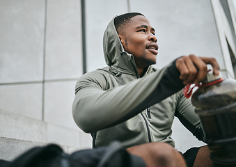 Image showing Fitness, gym or black man drinking water after training, exercise or workout for healthy body hydration. Relaxing, mindset or tired sports athlete with goals, motivation or mission resting in Chicago