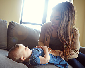 Image showing Mom, bonding or laughing baby girl in house living room or family home sofa in goofy, comic or funny tickle game. Smile, infant and happy mother playing with child after changing diapers on furniture