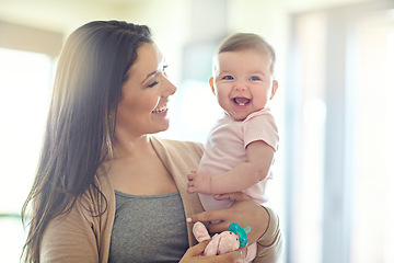 Image showing Mother, carrying or laughing baby girl in house living room, nursery or family home bedroom in trust, love or support. Smile, happy mom or infant child in funny, goofy and comic bonding game for kids