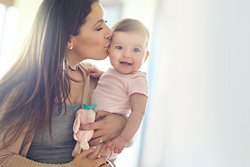 Image showing Mother, bonding and forehead kiss for baby girl on in house living room, nursery or family home bedroom in trust or love. Smile, happy and infant child with mom in support, security or safety comfort