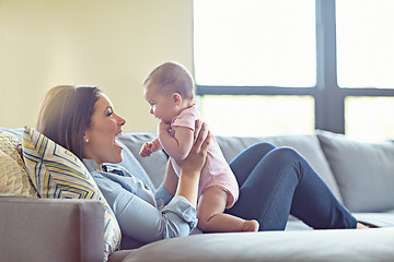 Image showing Woman, bonding and laughing mother with baby girl on house living room, relax nursery and family home sofa. Smile, happy and infant child with mom in comic, funny or silly children game in trust love