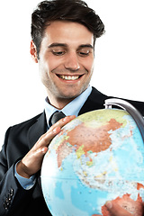 Image showing World, globe and business man with earth and planet sphere feeling happy about global travel. International, employee and happiness of a worker with isolated white background in a suit with a smile