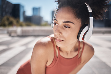 Image showing Fitness, headphones and tired black woman runner stop to relax or breathe on city run or workout. Health, urban training and wellness, woman on break from running exercise while streaming music app.