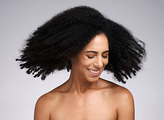 Image showing Beauty, black woman and afro shake for hair care campaign with playful smile and natural texture. Happiness, wellness and hair volume of african model with healthy skincare in white studio.