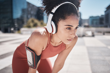 Image showing Phone, fitness app and headphones, tired black woman runner stop to relax or breathe on city workout run. Health, urban training and wellness, woman on break from running exercise and streaming music