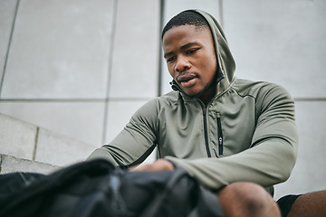 Image showing Fitness, runner and sports bag with a black man athlete taking a break from his exercise in the city. Workout, training and running with a sporty male exercising for sport in an urban town alone