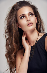 Image showing Beauty, makeup and hair care model thinking with edgy eyeliner aesthetic and hairstyle volume. Beautiful hair of young woman with salon cosmetic treatment shine on gray studio background