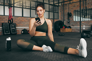 Image showing Fitness, phone and woman at gym for a workout, training and body wellness with a mobile app. Young sports female with smartphone for progress, performance and communication for a healthy lifestyle