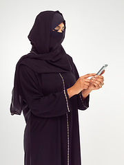 Image showing Muslim, phone and social media with an islamic woman in studio on a gray background for communication or networking. Contact, internet and islam with a female typing a text message or online post