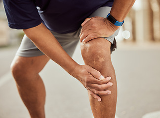 Image showing Fitness, knee pain and hands of black man with muscle ache, painful joint and injury after running in city. Sports, body wellness and male athlete rest after workout, marathon training and exercise