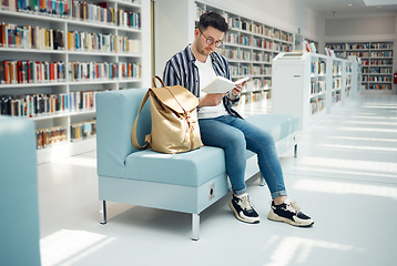 Image showing Library, reading and man with book on sofa for education, studying and academic research. University, scholarship and male student on couch for learning, hobby and knowledge in college bookstore