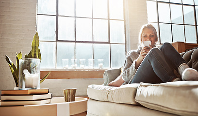 Image showing Living room, phone or relax and a woman in her home, sitting on the sofa with the sun shine through the window. Weekend, social media and communication with a young female relaxing in her house