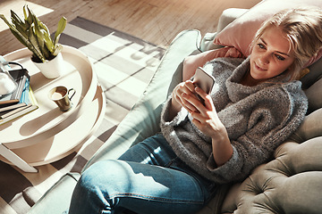 Image showing Top view, woman on sofa and smartphone for connection, social media and chatting in living room. Young female, girl and cellphone for conversation, relax and solitude in lounge on couch and happiness