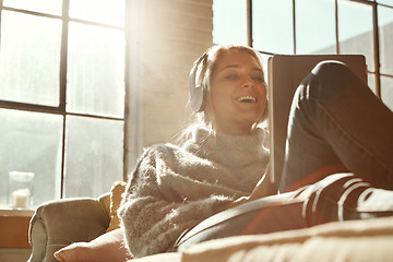 Image showing Woman, sofa and tablet with happiness, music or communication on internet to relax in lounge. Girl, couch and movie with headphones, mobile tech and streaming app for comedy, laugh and happy in house