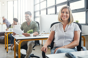 Image showing Business woman, smile and sitting at the desk happy for career, vision or ambition at office. Portrait of young female designer smiling in happiness for job, profession or occupation at the workplace