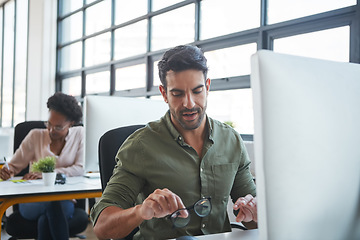 Image showing Working, business man and computer typing of a marketing employee in a office. Thinking, businessman and coworking workplace of a worker doing website ux strategy research cleaning glasses to work