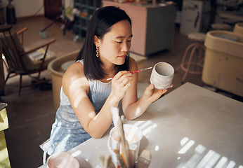 Image showing Pottery, art and ceramics with an asian woman in a studio for design or a creative hobby as an artisan. Manufacturing, pattern and artist with a female potter sitting in her workshop as a sculptor