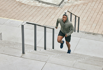 Image showing Runner, fitness and city stairs with a sports black man in the city for a cardio or endurance workout. Training, exercise or motivation with a male athlete running or moving up an urban staricase