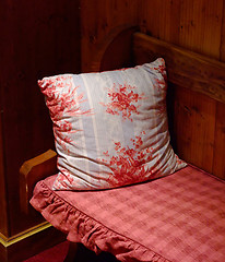 Image showing Red pillow kept on a wooden bench