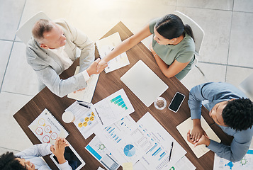 Image showing Business people, handshake and meeting with finance report documents for a b2b proposal with an accounting team. Men and women at table for planning with applause and shaking hands for profit growth