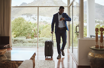 Image showing Travel, business and black man reading time, notification check and watch with luggage at a hotel. Schedule, late and African businessman with a smart watch for communication during a trip for work