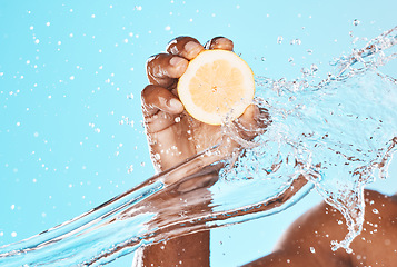 Image showing Water splash, lemon and man beauty with hands for healthy skincare, wellness and dermatology. Vitamin c, citrus fruits and shower on blue background for natural diet, water drops and detox cosmetics