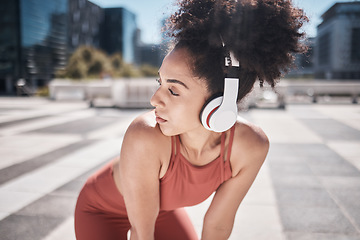 Image showing Black woman, fitness and listening to music in the city on a break from running exercise or workout. African American woman runner with headphones for sports training or audio track in the outdoors