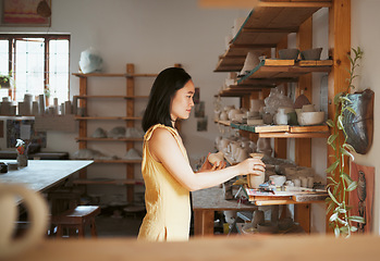 Image showing Woman, ceramic product and shelf in workshop, creative studio and manufacturing startup. Female small business owner, pottery designer and artist working with sculpture, creativity and craft process