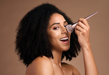 Image showing Black woman, studio portrait and makeup brush for foundation, beauty and cosmetic self care by backdrop. Model, happy and powder on nose, face and smile for skincare glow by brown studio background