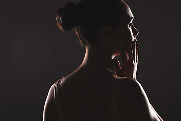 Image showing Creative, beauty and woman silhouette in a studio with a seductive, mysterious or sexy aesthetic. Art, face and profile facial shadow figure of a girl model isolated by a dark black background.