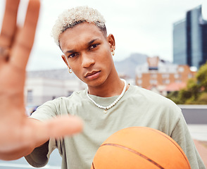 Image showing Sports, selfie and basketball player with fashion with a ball standing on an outdoor court. Fitness, edgy and cool man model and athlete from Brazil posing for a picture with a casual outfit in city