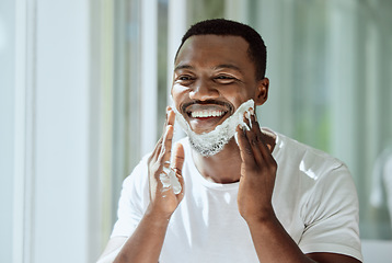 Image showing Shaving, cream and black man grooming face for clean look, hygiene care and beauty morning routine in the bathroom. Skincare, happy and African person ready to shave beard and facial hair with foam