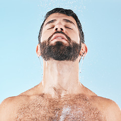 Image showing Man in shower, water and clean body with hygiene, grooming and skincare against blue studio background. Cleaning face, model with water drops and facial, natural treatment and cosmetic mockup