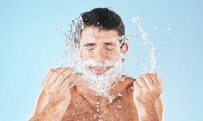 Image showing Man, shave and face with water splash in studio for wellness, health and self care by blue background. Model, bathroom and smile with splash for facial beauty, skin product and cosmetics by backdrop