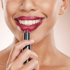 Image showing Lipstick, lips and woman with face and beauty, makeup with cosmetics closeup, teeth and dental against studio background. Cosmetic care, product and facial with smile, hand and skincare wellness