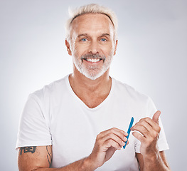 Image showing Portrait, nail file and beauty with a man in studio on gray background mockup for grooming, filing his finger nails. Manicure, wellness and cosmetics with a male taking care of his personal hygiene