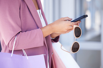 Image showing Woman, phone and shopping with sunglasses in hands while doing online shopping, ecommerce and internet banking. Female using mobile app for customer discount or coupon on commerce website at a mall