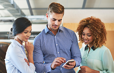 Image showing Phone, meeting and collaboration with a business team checking their schedule or calendar in the office. Teamwork, social media and contact with a man and woman employee group looking at a mobile