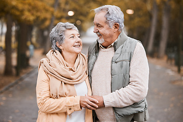 Image showing Senior couple, love and hug while walking outdoor for exercise, happiness and care at a park in nature for wellness. Old man and woman together in a healthy marriage during retirement with freedom