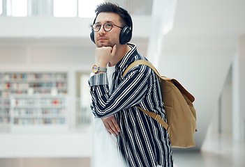 Image showing Thinking, headphones and library student at university, college or academy idea for research, learning and knowledge. Study, education and creative, geek man listening to audio for school inspiration